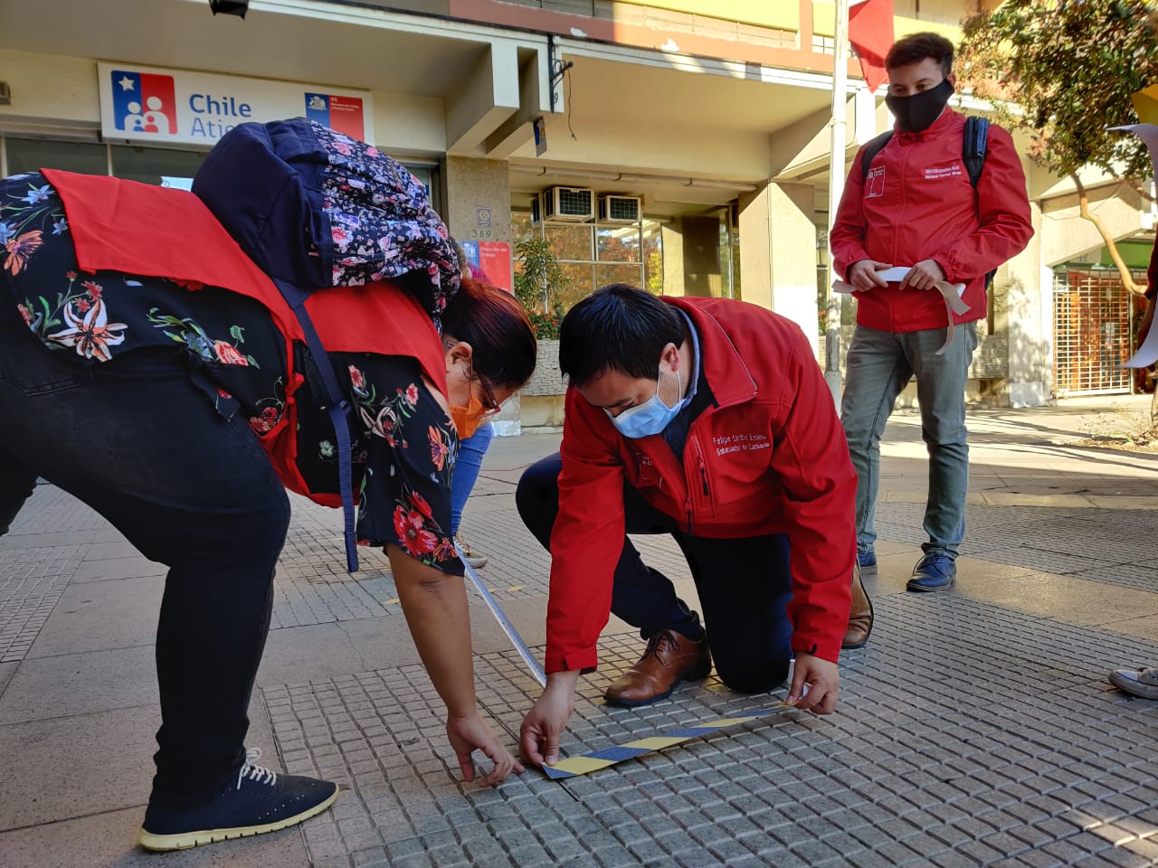 Jóvenes voluntarios realizan demarcación de distancia afuera de Chile atiende